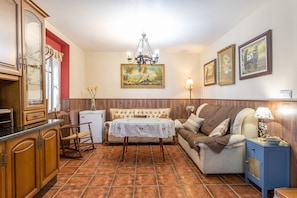 Una sala acogedora con una mesa de comedor, sofá y una mesita auxiliar con una lámpara.