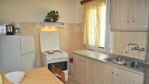 A compact kitchen with a stove, sink, and cabinets. - Beachfront Holiday House Eftichia (Corfu)