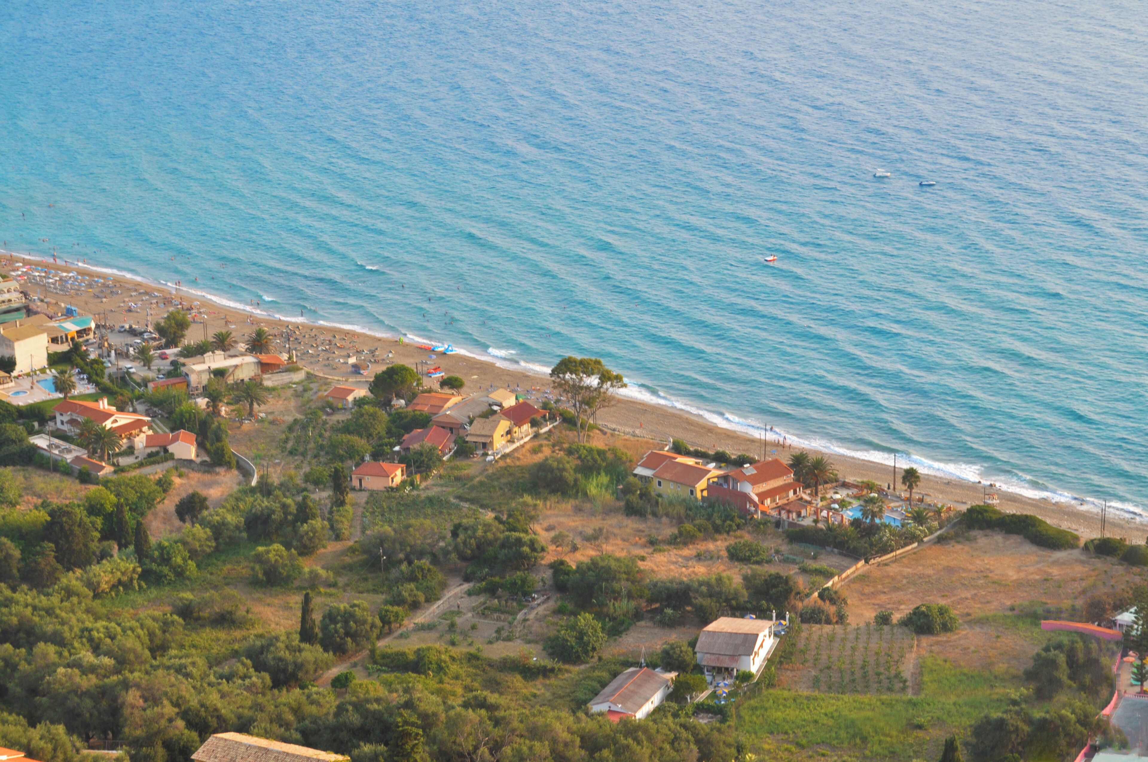 Une vue aérienne d’une ville côtière, avec des maisons le long de la plage et une vue dégagée sur la mer.