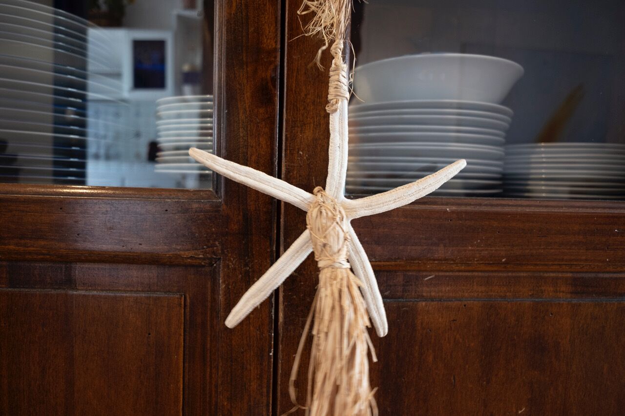 Una decoración de estrella de mar colgando de una puerta de madera.