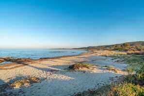 A beach with clear skies, sandy shore, and distant hills. - Centrally Located, Mediterranean Holiday Apartment with Garden and Terrace; Pets Allowed (san teodoro)
