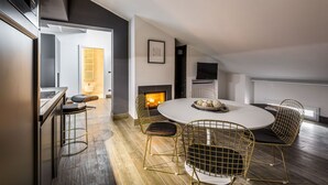 Un comedor moderno con una mesa redonda, sillas de estructura metálica y una chimenea.