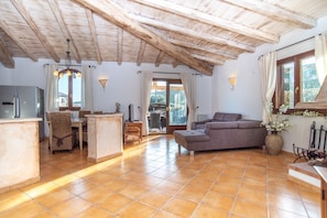 A spacious living area with a kitchen, dining table, and a sofa.