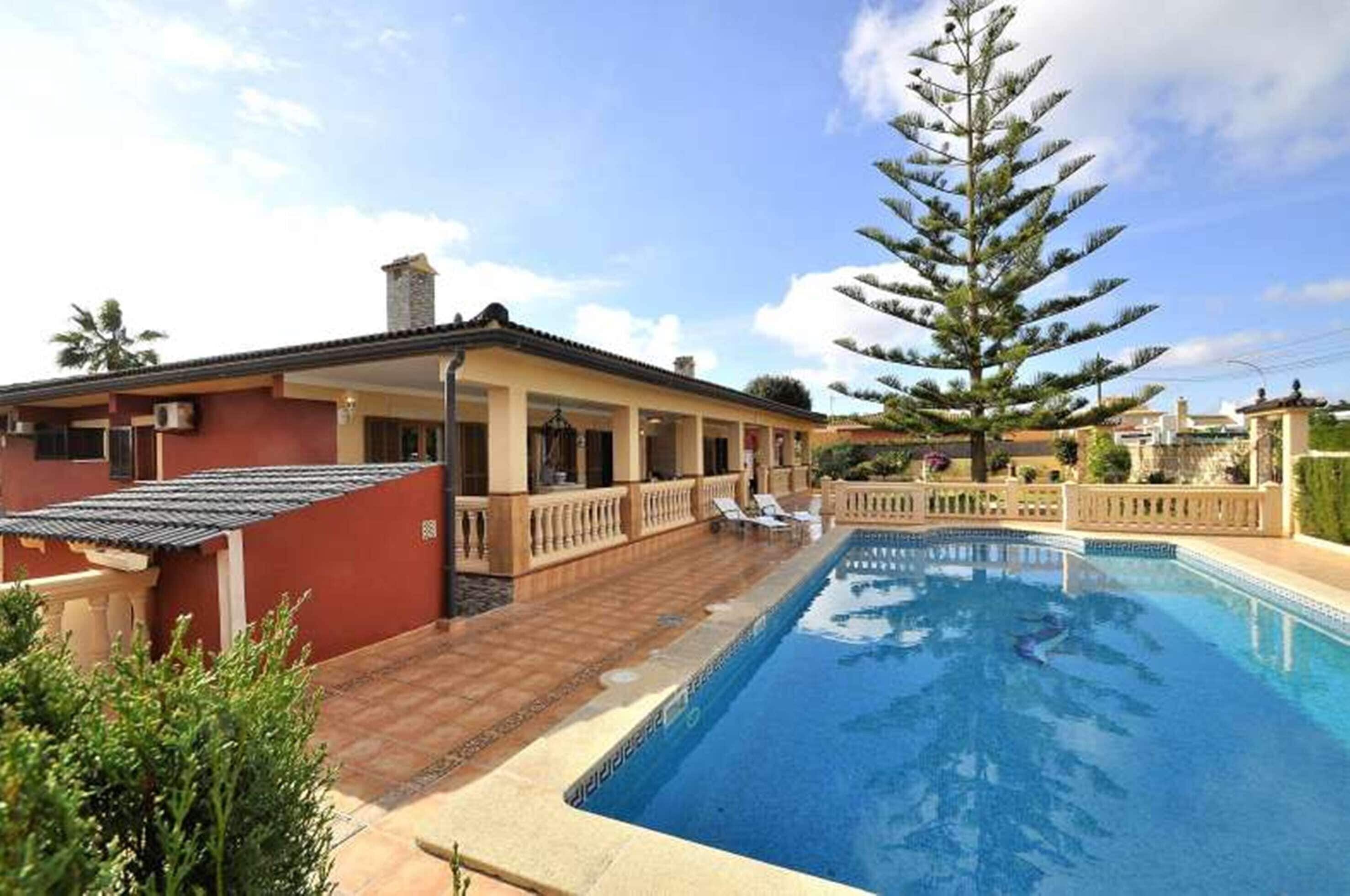 A swimming pool with a house in the background.