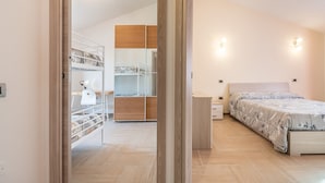 Un dormitorio con cama, mesita de noche, armario y espejo.