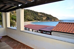 Un balcon avec vue sur la plage et une enseigne indiquant « BACARDI ».