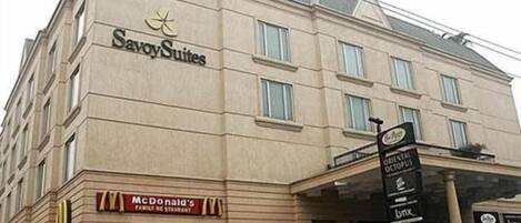 A hotel with a Savoy Suites sign, a McDonald's Family Restaurant, and a sign for the Oriental Octopus restaurant.