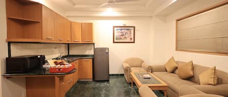 Un espacio habitable compacto con cocina, sofá y ventilador de techo.