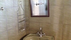 A bathroom with a sink, mirror, and towel rack. - Dream Heart Lodge (Ndola)