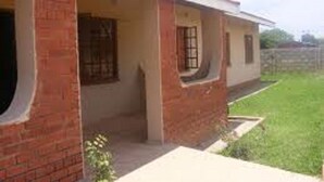 A single-story building with a brick facade and a flat roof. - Dream Heart Lodge (Ndola)