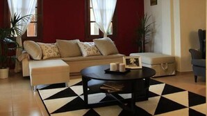 Ein Wohnzimmer mit einer Couch, einem Couchtisch und einem gemusterten Teppich.
