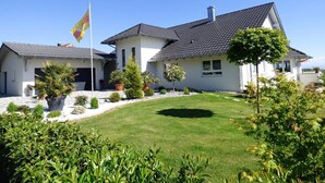 A two-story house with a well-maintained lawn and potted plants. - Wonderful Apartment in the house Seeblick (Salem)