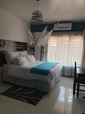 Cubrecamas, escritorio y espacio para trabajar con laptop