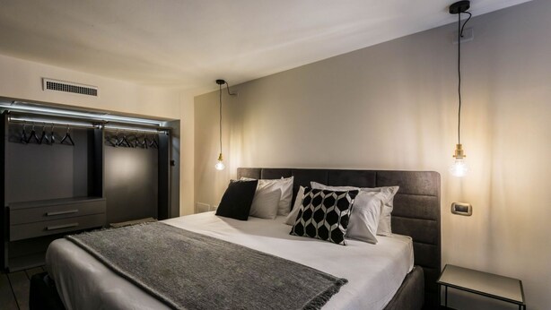 A modern bedroom with a large bed, a wardrobe, and two pendant lights. - 18 · Extreme design style - Bologna Downtown Apartment (Bologna)