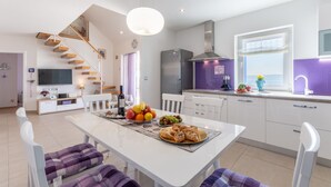 A modern kitchen with white cabinets, a built-in oven, and a window with a view. - Villa Blue Sky (Bol)