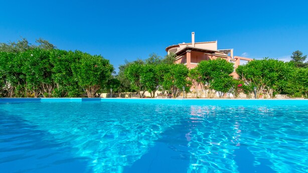 A clear blue pool with a building in the background. - Villa Leo 1 , Dassia , Corfu (Corfu)