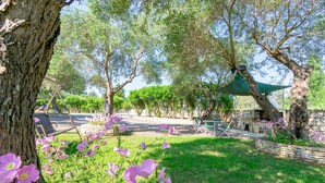A park with trees, a grassy area, and a stone wall. - Villa Leo 1 , Dassia , Corfu (Corfu)