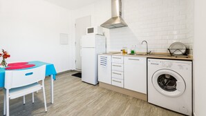 A compact kitchen with a washing machine, a microwave, and a sink.
