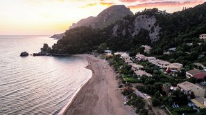Eine Küstenlandschaft mit Strand, Häusern und einem Berg.
