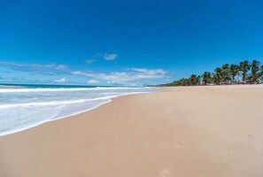 Na praia, espreguiçadeiras, toalhas de praia 