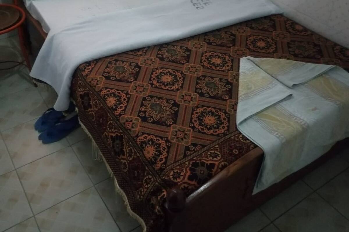 Una cama individual con una colcha estampada y almohadas que dicen "CHOICES LONG TERM".