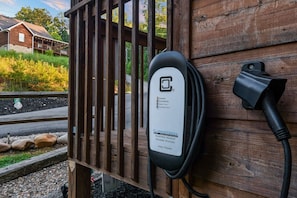An electric vehicle charging station attached to a wooden structure. - Creekside On The Bluff 2 Bedroom Cabin by RedAwning (Sevierville)