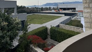 Een dak met uitzicht op bergen, een parkeerplaats en een gebouw in aanbouw.