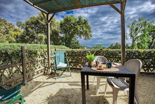 An outdoor seating area with a table, chairs, and a pergola.