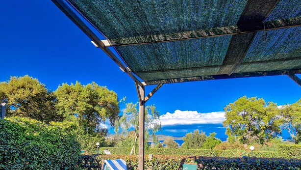 A covered outdoor seating area with a view of the sky and trees. - Well-kept and with great views - Appartamenti Le Querce - Melograno (Capoliveri)