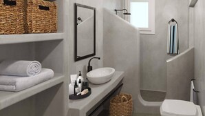 Un baño moderno con un lavabo blanco, un espejo grande y una zona de ducha. Hay cestos de mimbre y toallas en estantes.