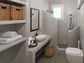 A modern bathroom with a white sink, a large mirror, and a shower area. There are wicker baskets and towels on shelves.