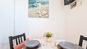 Una mesa de comedor con dos platos, dos vasos y una pequeña maceta.