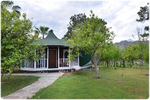 A small, single-story structure with a green roof, a porch with white railings, and a door. - Arcadia Hotel (Kemer)