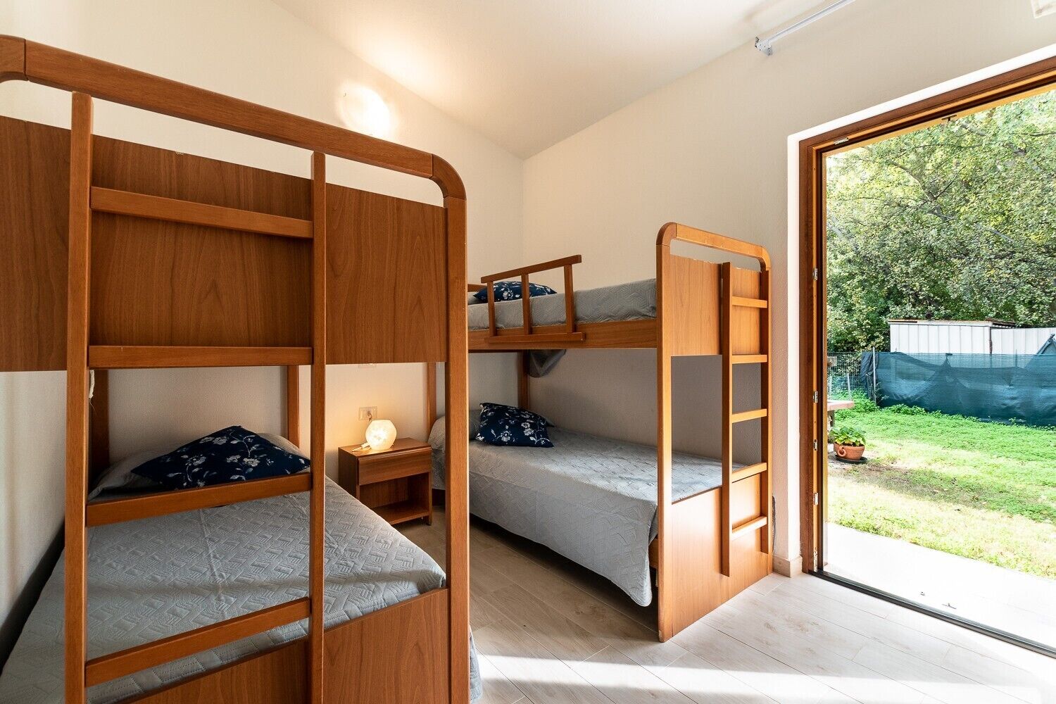 Ett rum med en våningssäng, ett litet bord och ett fönster ut mot omvärlden.
