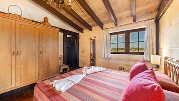 A room with a bed, wooden wardrobe, and a window with a view.