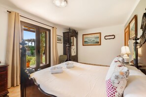A hotel room with a bed, a chair, a desk, a lamp, and a painting on the wall. - Spacious Mallorcan Villa “Es Rafal Nostro 11” with Pool (Felanitx)