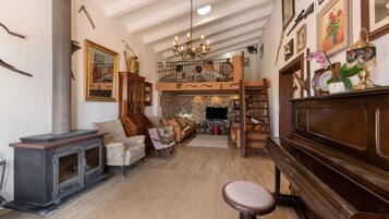 Una sala de estar acogedora con chimenea, asientos cómodos y un piano.