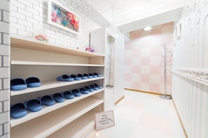 A shoe display with a sign instructing to take shoes off here.
