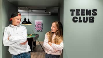 A hallway with a sign reading 'TEENS CLUB' on the wall.