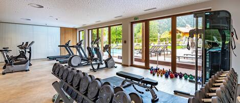 A gym with various exercise equipment, including treadmills, ellipticals, and weight machines.