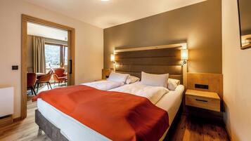 Habitación de hotel con una cama grande, una mesita de noche y vistas al exterior a través de una ventana.