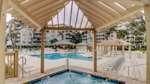 A pool area with a hot tub, lounge chairs, and umbrellas. - 6204 Hampton Place - Oceanfront Views, Pool, Spa & So Much More! (Hilton Head Island)