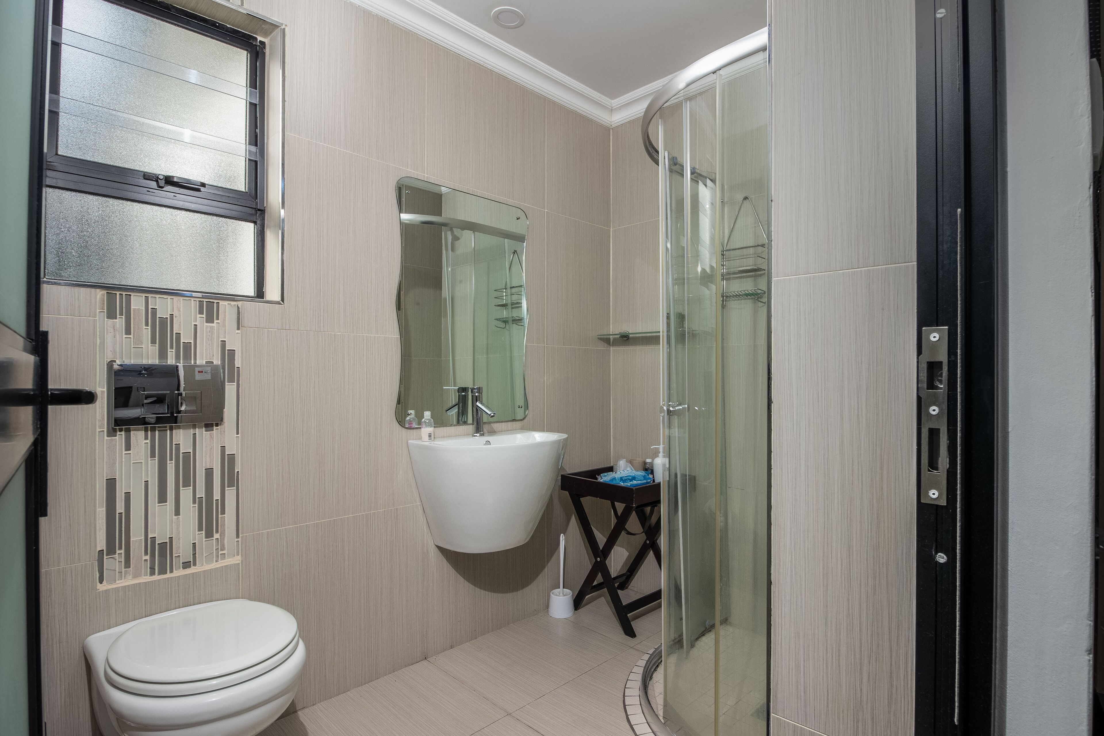 Un baño moderno con inodoro, lavabo y cabina de ducha de vidrio.