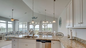 A spacious kitchen with a large island, white cabinetry, and pendant lighting. - Island Oasis, Elevator, Beautiful Decor (Topsail Beach)