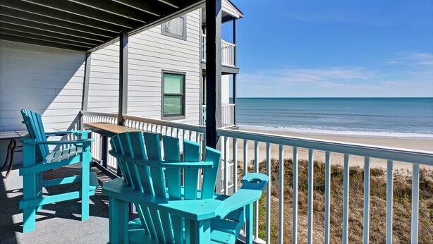 A balcony with turquoise Adirondack chairs overlooking a beach. - Oceanfront Condo with amazing views of The Atlantic (North Topsail Beach)