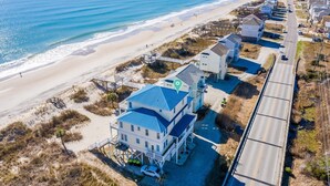 A coastal property with a beach view, a pier, and a road leading to a gated community. - SeaBee Surf-Oceanfront Hot Tub,240 EV outlet,Elevator,Sleeps 18,pet friendly (North Topsail Beach)