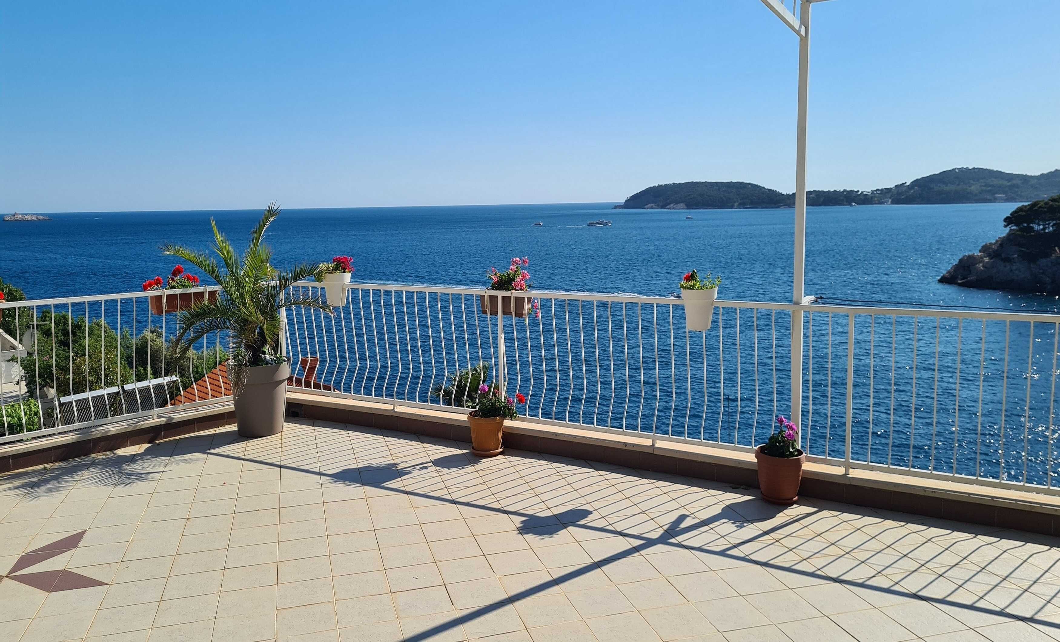 Un balcon agrémenté de plantes en pot et offrant une vue sur la mer.