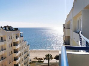 Un hotel costero con balcones con vistas a la playa y al mar.