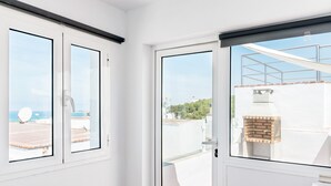 Un balcón con vista a una piscina, un horno de ladrillo y un cielo despejado.