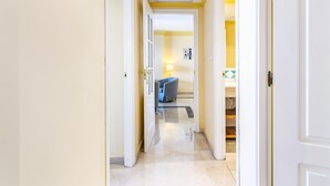 A hallway with a blue sofa, a lamp, and a tiled floor. - Apartamento en Marbella con vistas laterales al mar 328 (Marbella)